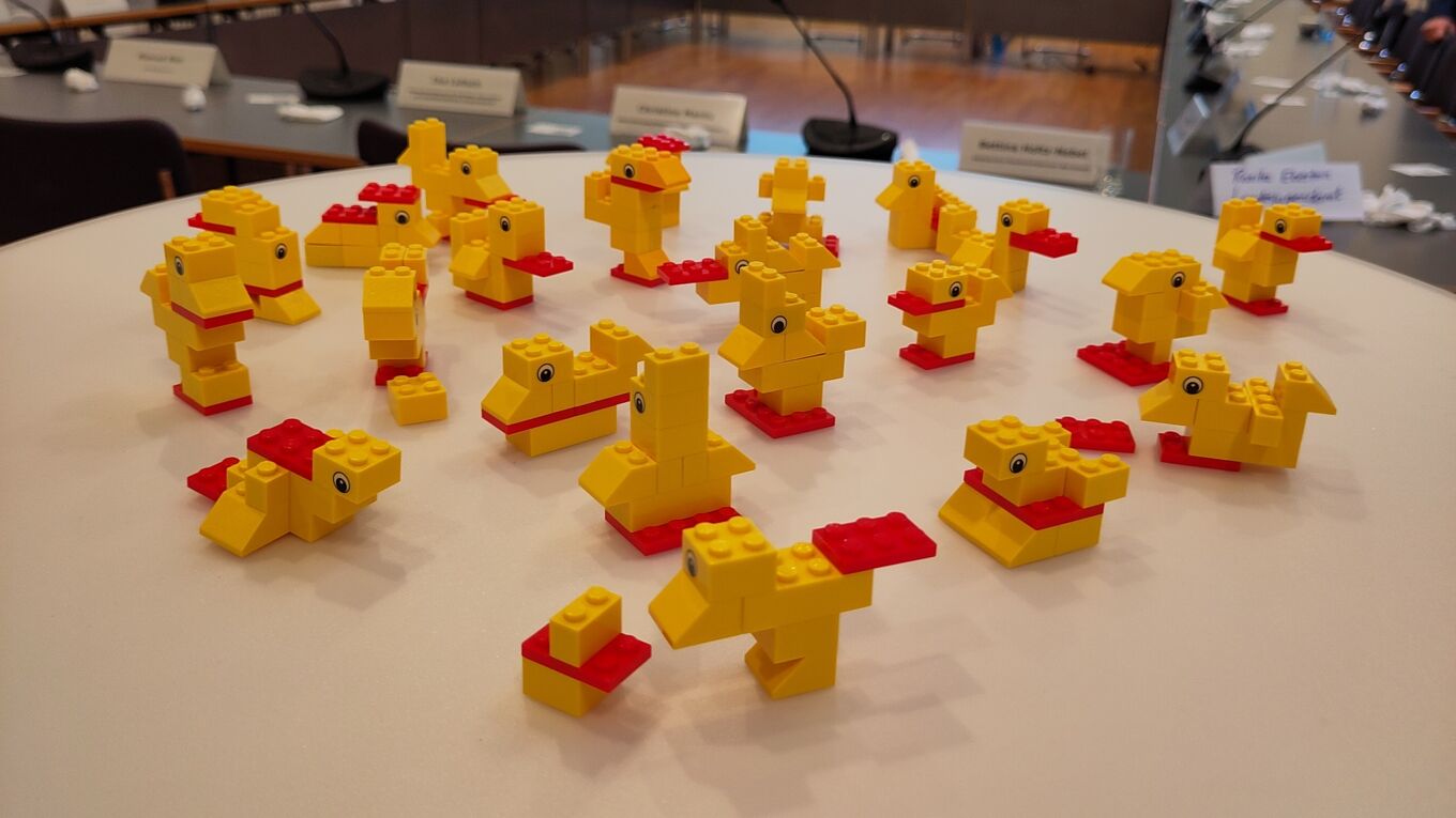 man sieht verschiedene kleine Enten aus Lego, welche alle Mitglieder aus den gleichen Bauteilen gebaut haben