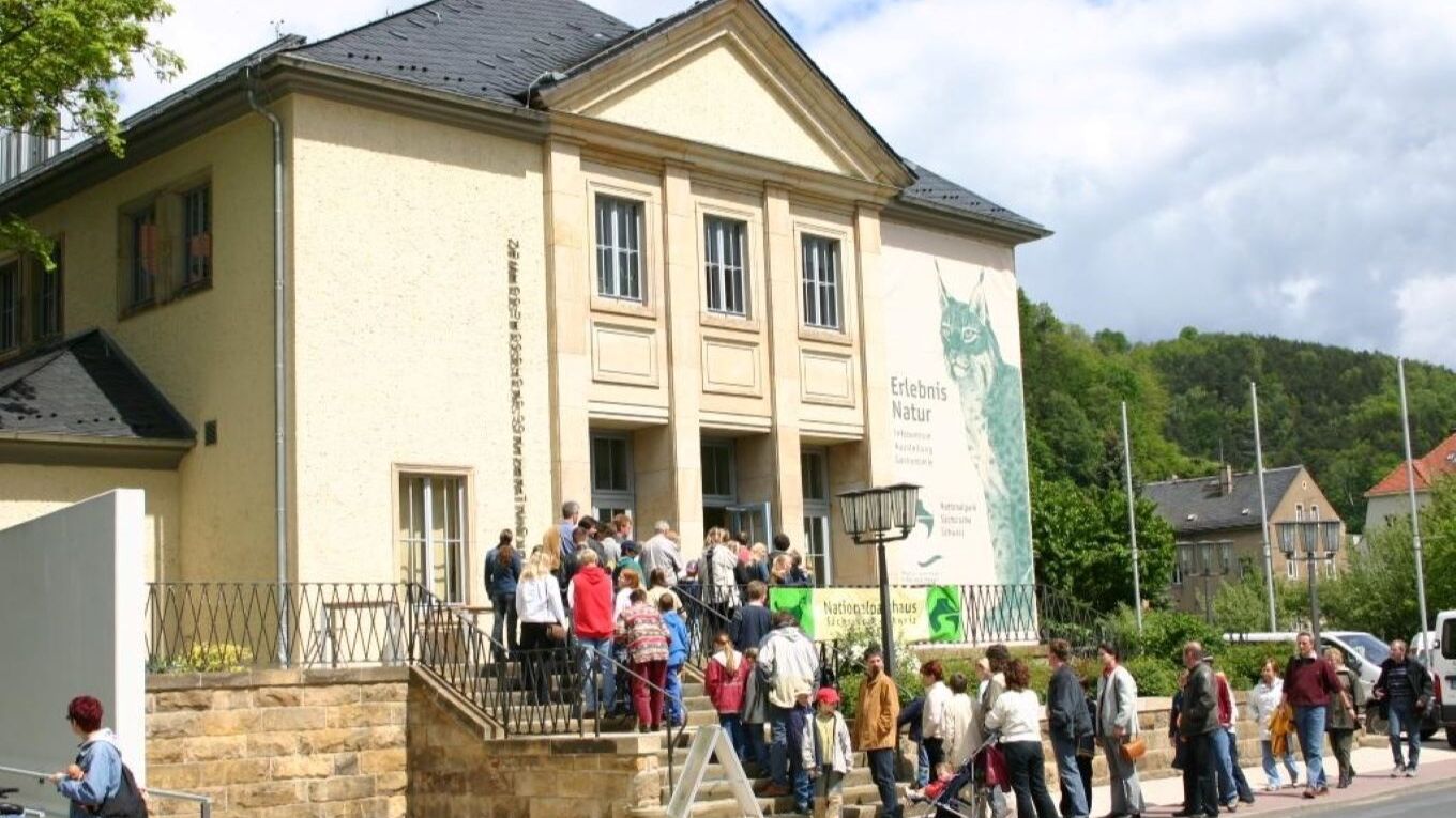 Zu sehen ist der Eingangsbereich des Nationalparkzentrums Bad Schandau mit einer Schlange von Besuchern.