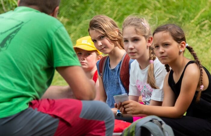Fünf Kinder und ein Referent einer Umweltbildungsveranstaltung im Freien.