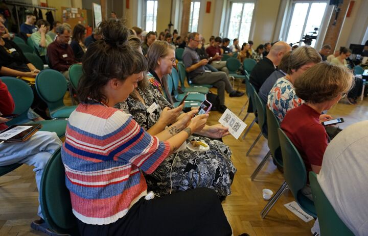 Teilnehmende nehmen über Smartphone bei Slido teil