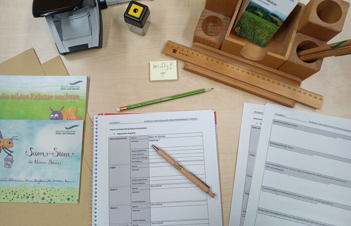 Antragsformular, Stifte und weiteres Büromaterial auf einem Schreibtisch. - Link: Finanzielle Unterstützung der Naturschutzstationen