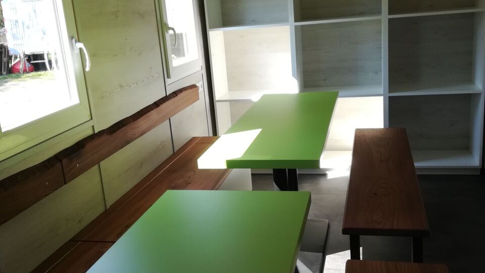Innenansicht eines Bauwagens. Tische, Stühle in der Art eines Klassenzimmers.