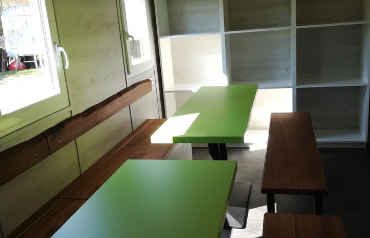 Innenansicht eines Bauwagens. Tische, Stühle in der Art eines Klassenzimmers.
