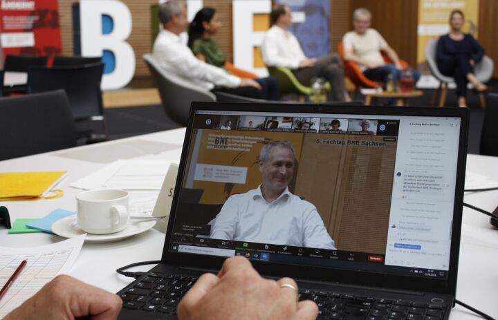 Podium im Hintergrund, Fordergrund Laptop um das hybride Format zu zeigen