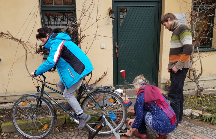 Seminarteilnehmende testen eine Fahrradkonstruktion, die Strom generiert