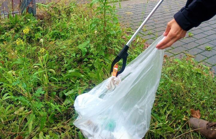 Eine Person packt Müll vom Straßenrand mit einem Müllgreifer in eine Mülltüte. - Link: Gemeinsam in Dresden dem Müll zu Leibe rücken