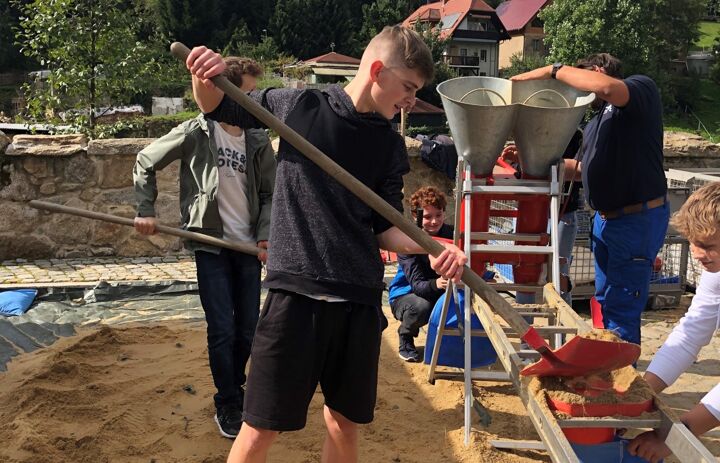 Schüler befüllen Sandsäcke für den Hochwasserschutz