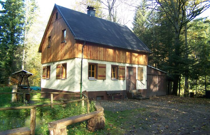 Zu sehen ist ein kleines zweistöckiges Waldhaus. Es dient dem Grüne Aktion Westerzgebirge e.V. als Waldstation.
