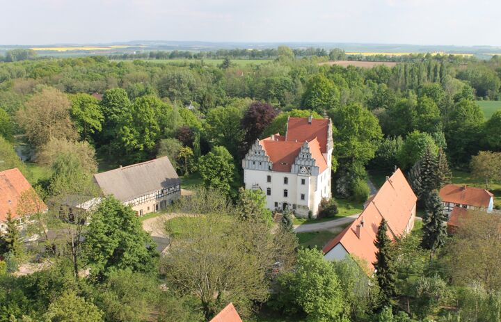 Ansicht der Schlossanlage Heynitz mit Schloss, Wirtschaftsgebäuden und Umgebung - Link: NABU-Naturschutzstation Schloss Heynitz