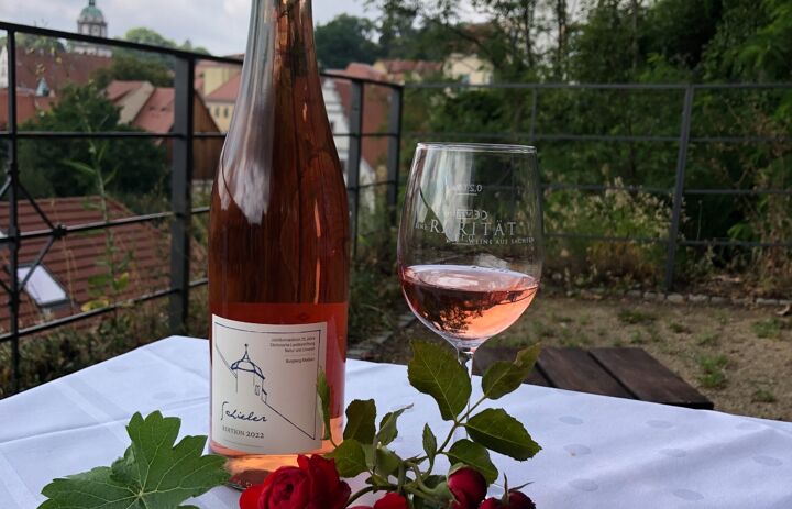 Gedeckter Tisch mit Weinflache Rebsorte Schieler und Weinglas